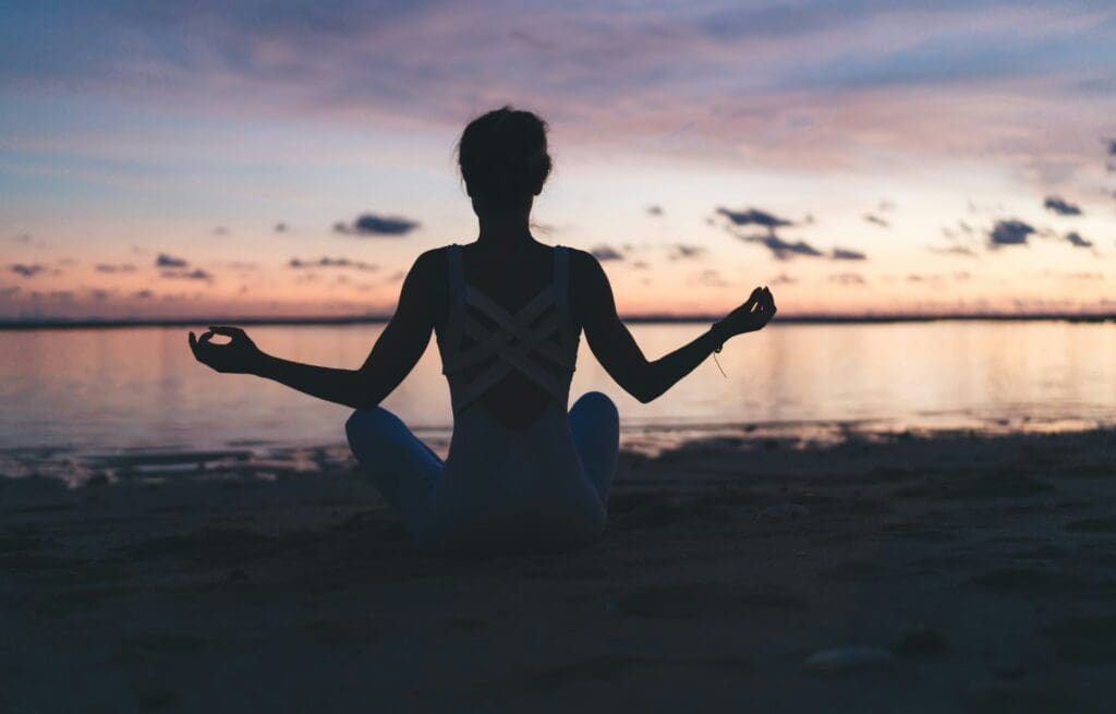 Mental harmony and meditation training during evening yoga at coastline beach