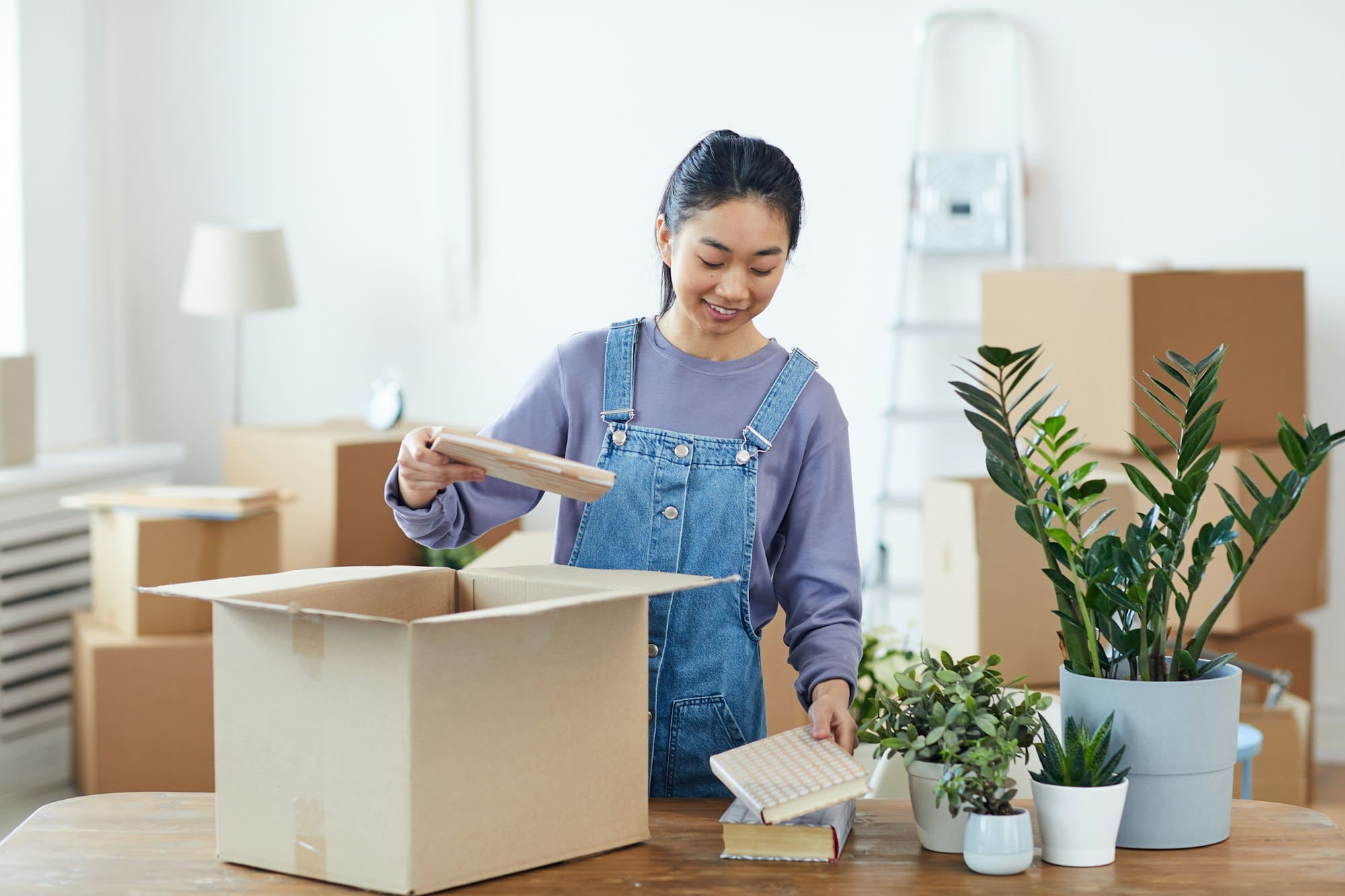 Asian Student Unpacking Boxes in Dorm