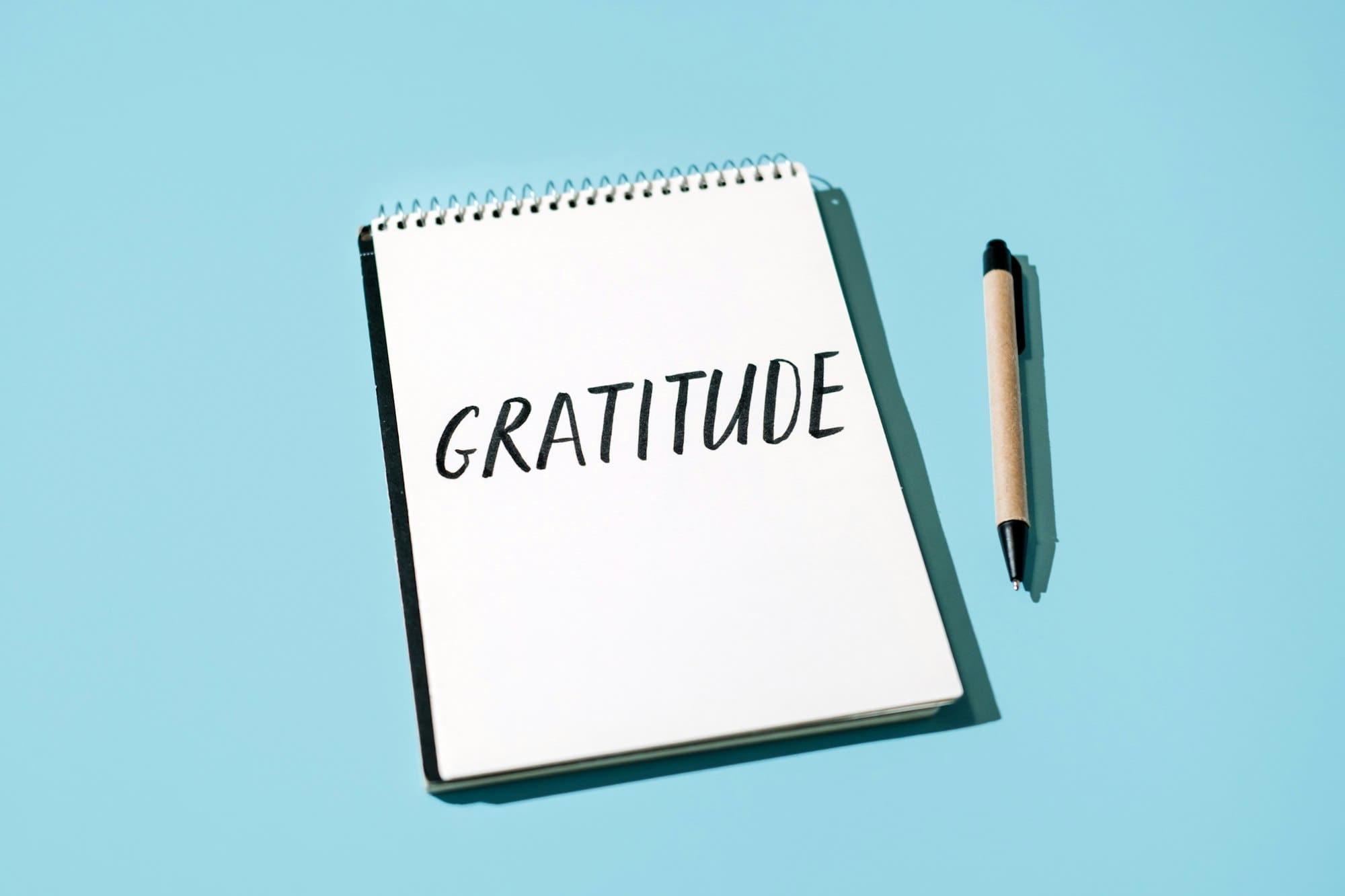 How to Practice Gratitude. Word Gratitude in open notebook on table.