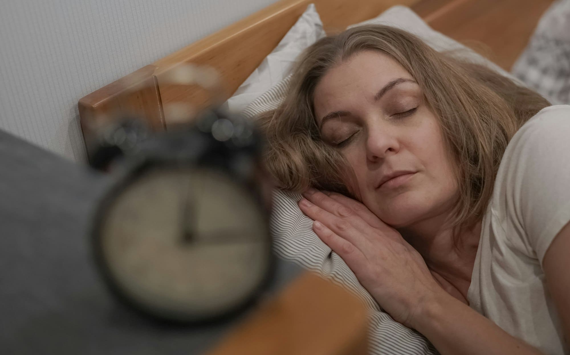 Sleeping woman, bedtime, an alarm clock