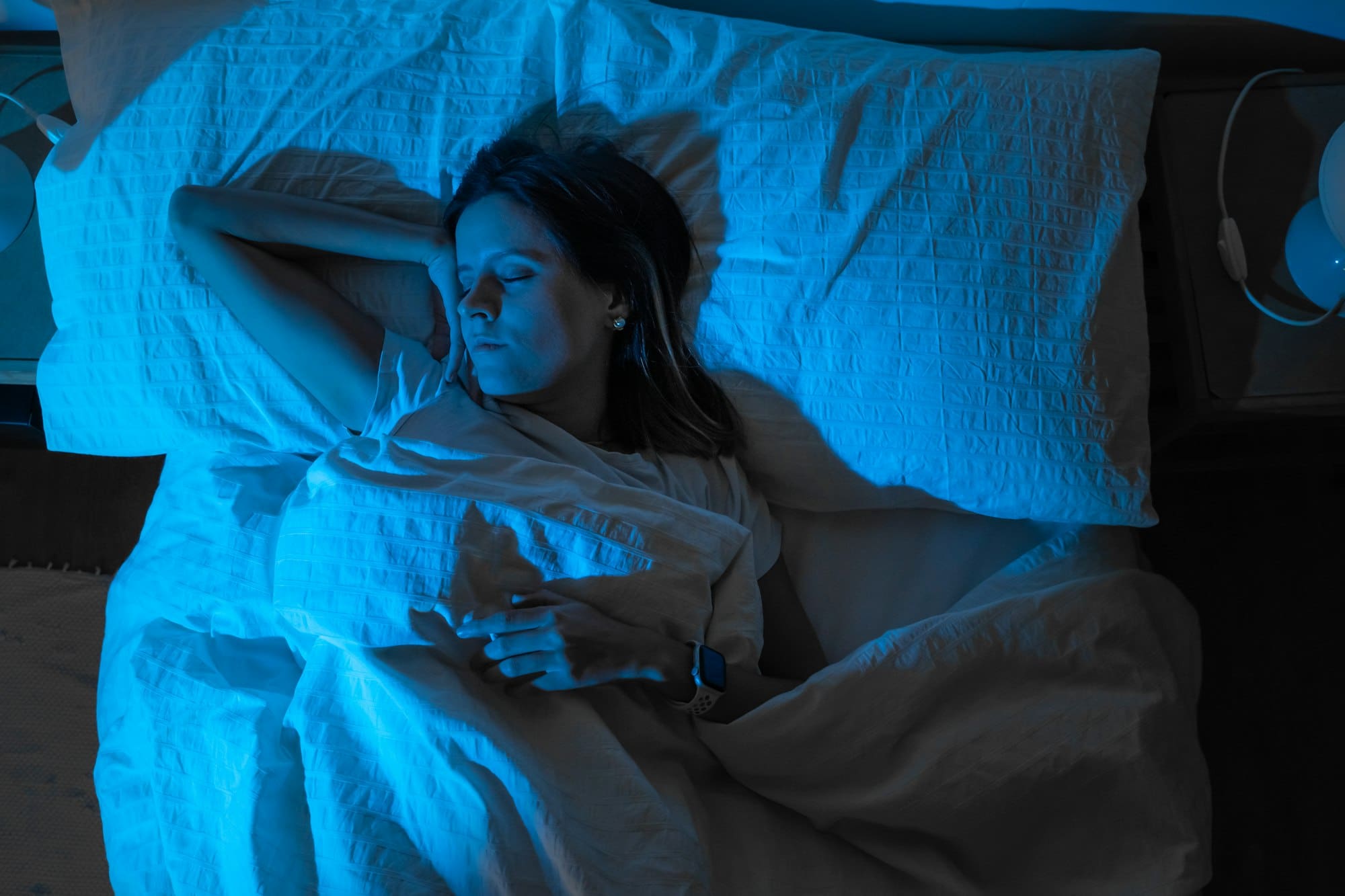 Top view of a beautiful girl sleeping cozily on a bed in her night room.