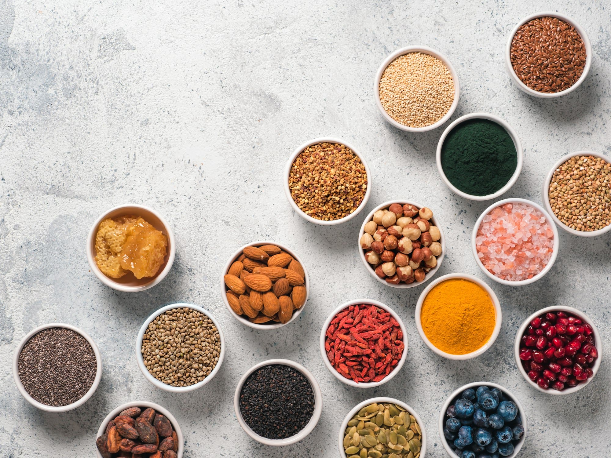 Various superfoods in bowl on gray background